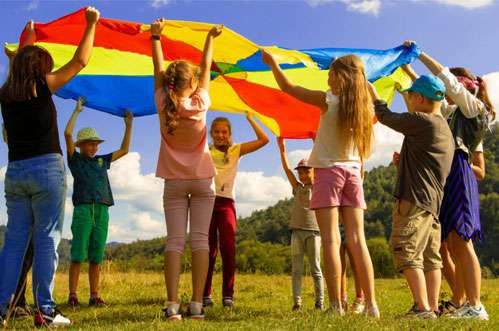 Children raising a colorful parachute above their heads